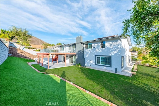 rear view of house featuring a patio area and a lawn