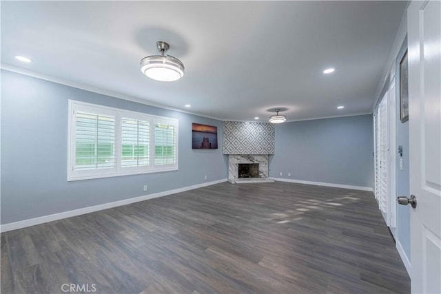 unfurnished living room featuring dark hardwood / wood-style floors, a fireplace, and crown molding