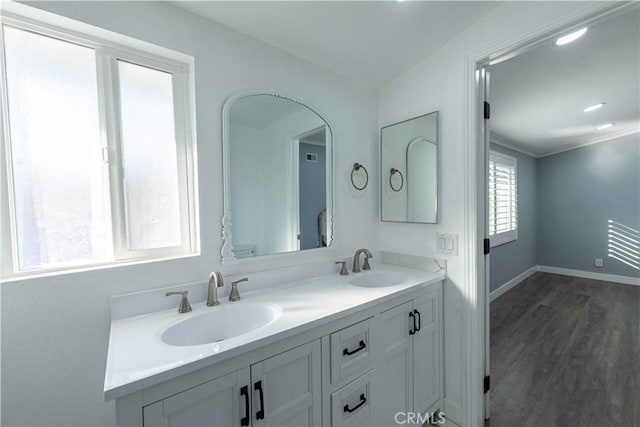 bathroom with vanity, hardwood / wood-style flooring, and crown molding