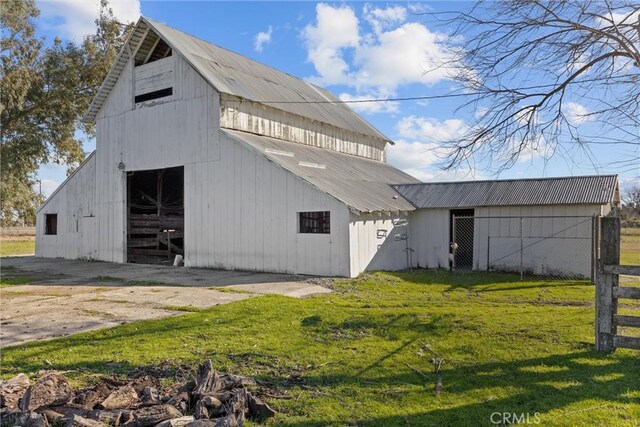 view of property exterior with a barn, a garage, metal roof, and an outdoor structure