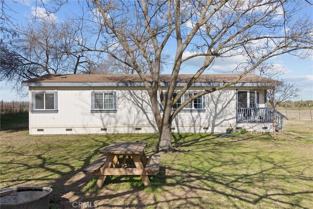 exterior space with roof with shingles, crawl space, and a lawn