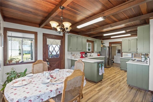 kitchen with green cabinets, light countertops, white microwave, and freestanding refrigerator