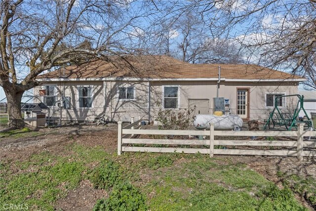 back of house featuring fence and stucco siding