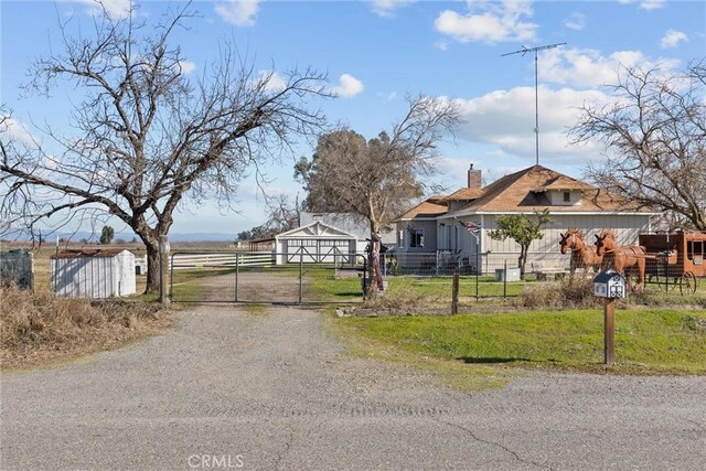 view of road with a rural view, a gated entry, gravel driveway, and a gate