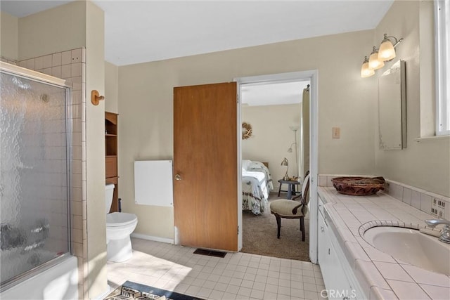 bathroom with toilet, tile patterned floors, vanity, and ensuite bathroom