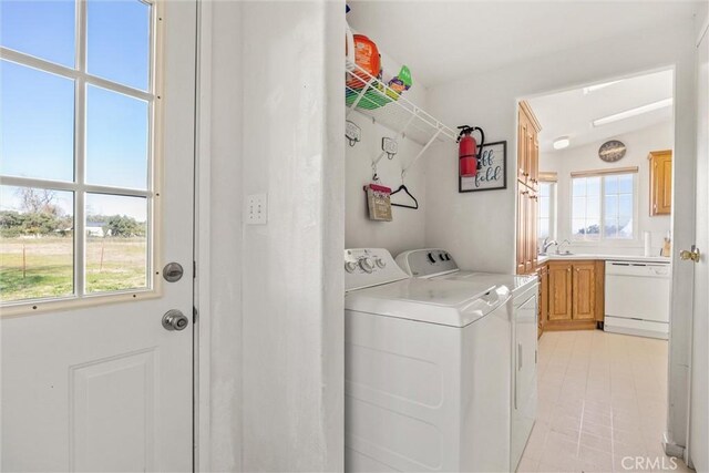 clothes washing area with a sink, laundry area, and washer and dryer