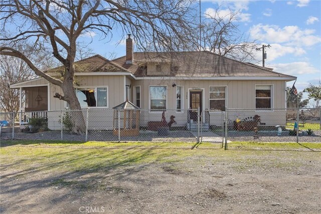 view of front of home featuring a fenced front yard, a chimney, and a gate