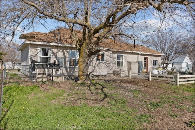 back of property with fence and a yard