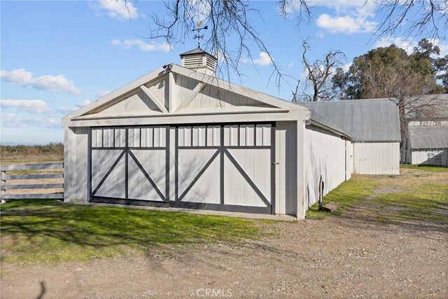 view of outbuilding featuring fence and an outdoor structure