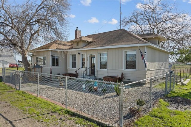 view of front of home featuring a fenced front yard, crawl space, and a chimney