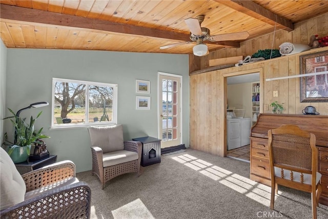 sitting room featuring vaulted ceiling with beams, light carpet, wood walls, wood ceiling, and washer and dryer