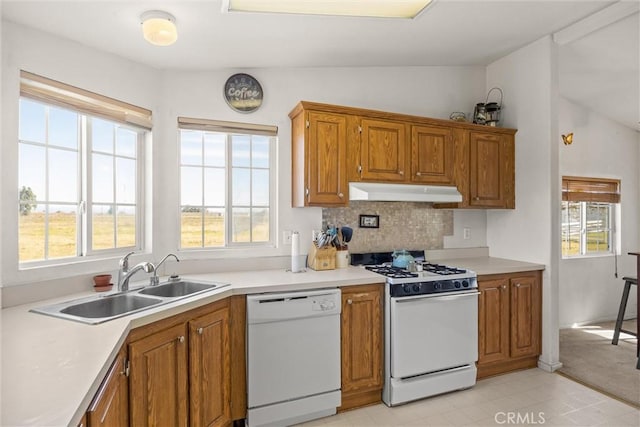 kitchen featuring white appliances, light countertops, a sink, and under cabinet range hood