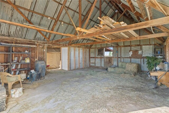 miscellaneous room featuring vaulted ceiling and metal wall