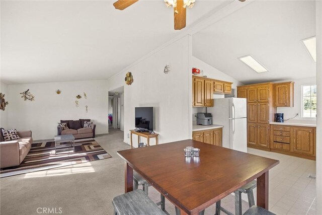 dining area with a ceiling fan, lofted ceiling, and light carpet