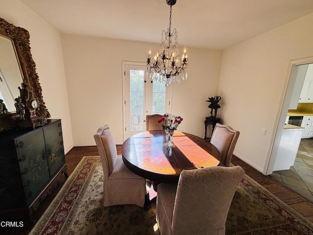 dining space with baseboards and a chandelier