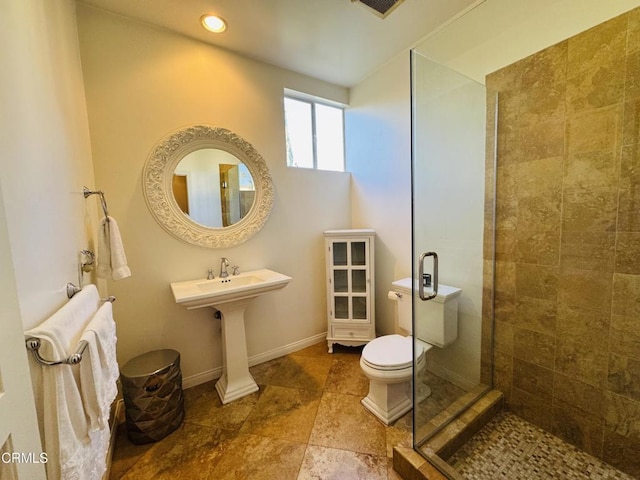 bathroom with a shower stall, toilet, and baseboards