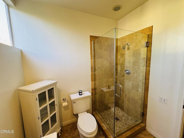 bathroom featuring baseboards, a shower stall, and toilet