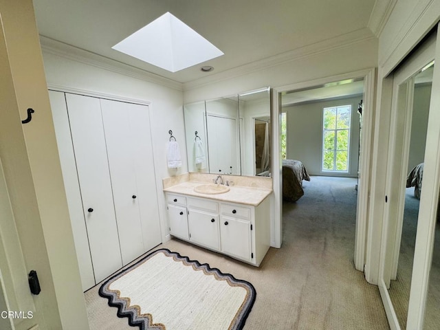 ensuite bathroom with ensuite bath, ornamental molding, vanity, and a skylight