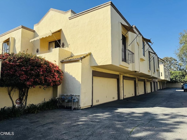 view of side of property featuring stucco siding and a balcony