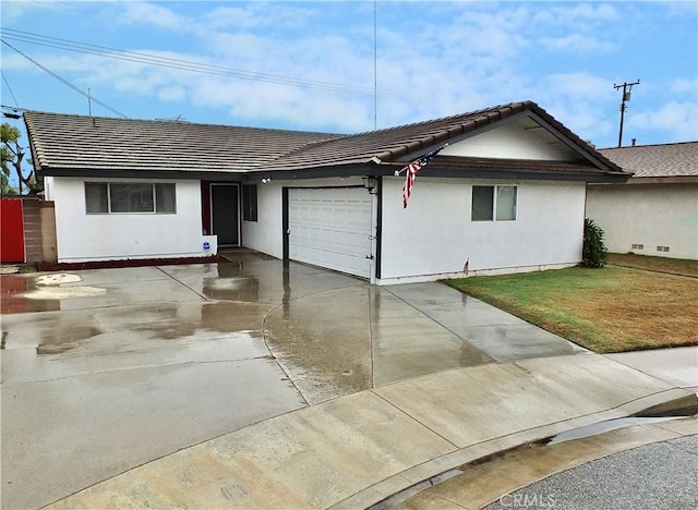 ranch-style house featuring a garage and a front yard