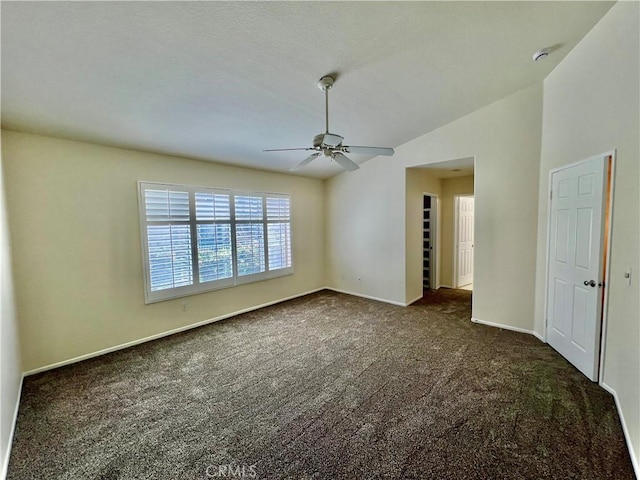 spare room with lofted ceiling, ceiling fan, and dark colored carpet