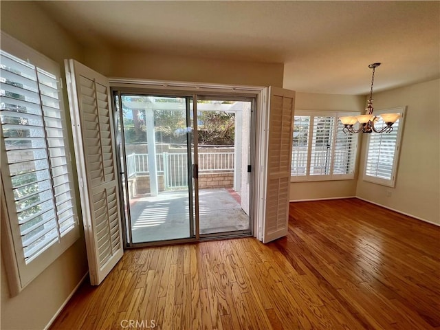 doorway to outside featuring hardwood / wood-style flooring and an inviting chandelier