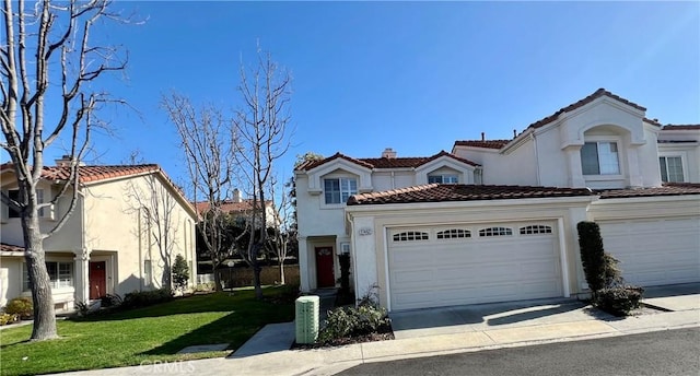 mediterranean / spanish home with a garage and a front lawn