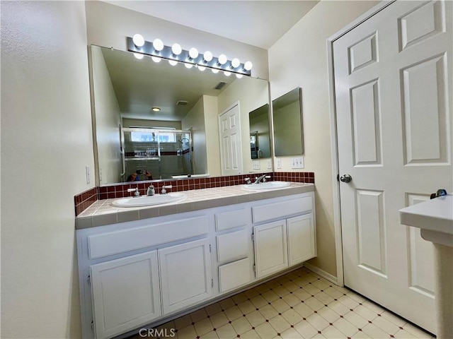 bathroom featuring vanity, an enclosed shower, and decorative backsplash