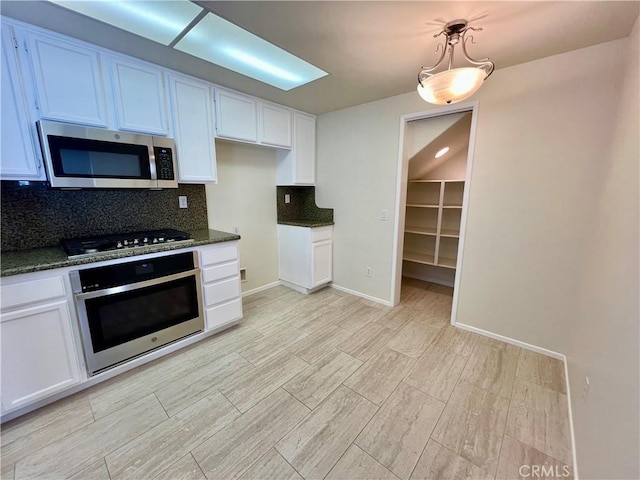 kitchen with stainless steel appliances, decorative light fixtures, and white cabinets