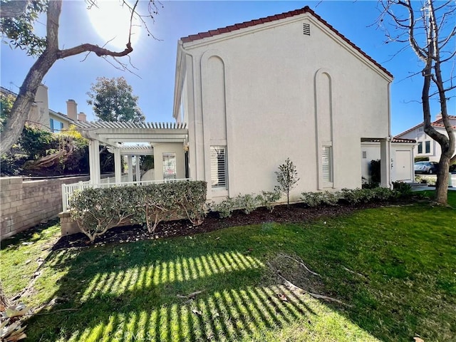 view of side of home featuring a yard and a pergola