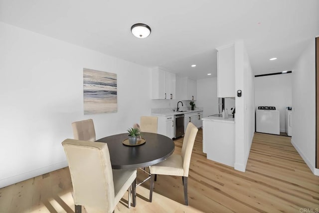 dining space with sink, separate washer and dryer, and light hardwood / wood-style floors