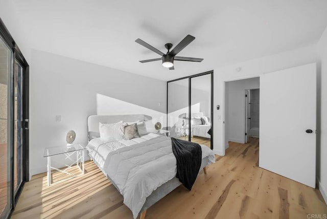 bedroom featuring ceiling fan, light wood-type flooring, and a closet