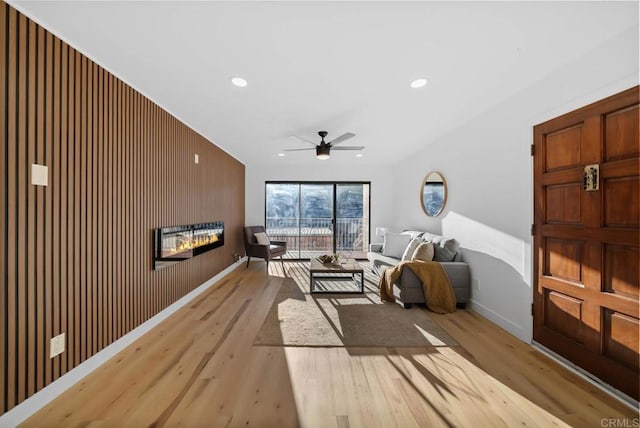 interior space featuring wooden walls, ceiling fan, and light wood-type flooring