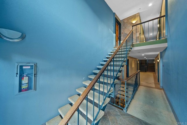 staircase featuring a towering ceiling