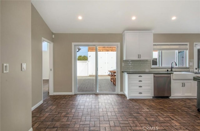 kitchen featuring white cabinetry, backsplash, a healthy amount of sunlight, and dishwasher