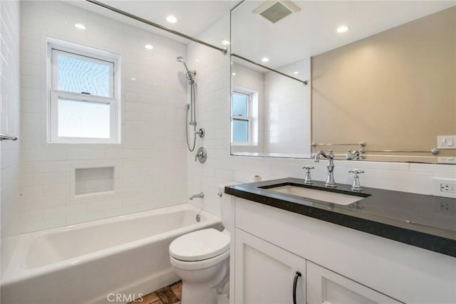 full bathroom featuring tiled shower / bath, plenty of natural light, vanity, and toilet