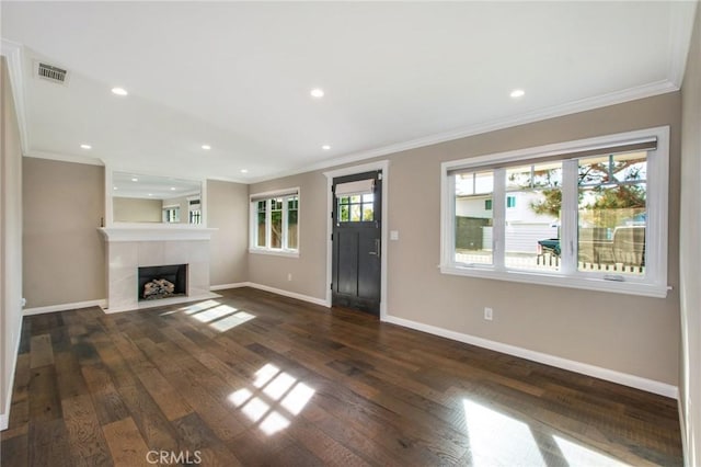 unfurnished living room featuring dark hardwood / wood-style flooring, crown molding, and a fireplace