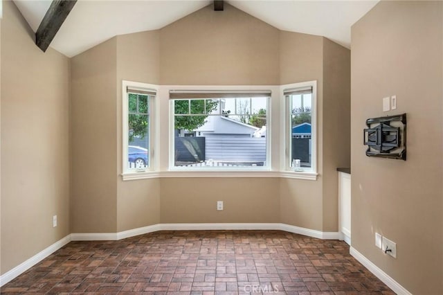 unfurnished room with vaulted ceiling with beams