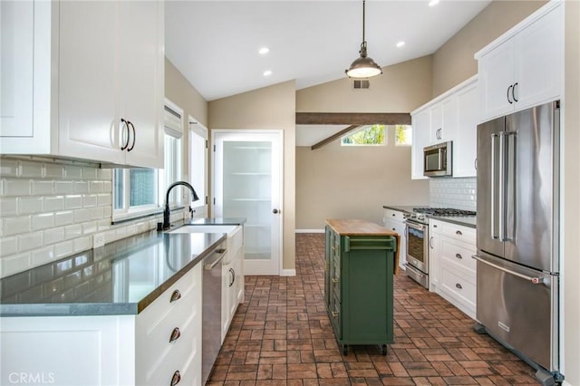 kitchen with pendant lighting, white cabinetry, sink, premium appliances, and a center island