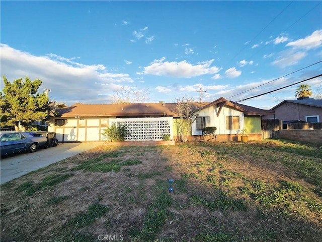 view of front facade featuring a garage, fence, and driveway