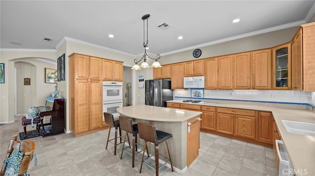 kitchen featuring white appliances, a kitchen island, glass insert cabinets, and light countertops