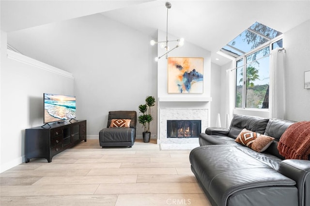 living room featuring a chandelier, high vaulted ceiling, and light hardwood / wood-style flooring