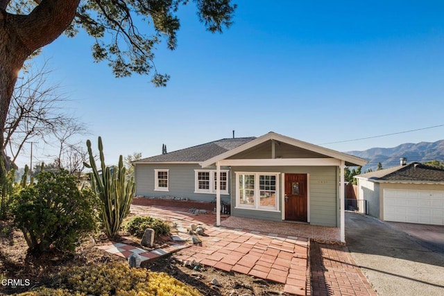 rear view of house featuring a garage and a mountain view