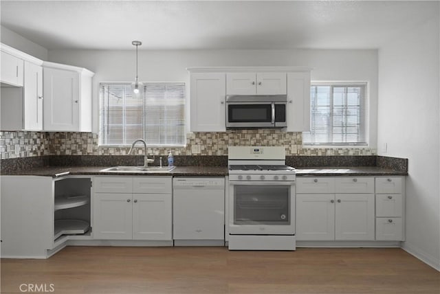 kitchen featuring sink, white appliances, decorative light fixtures, and white cabinets