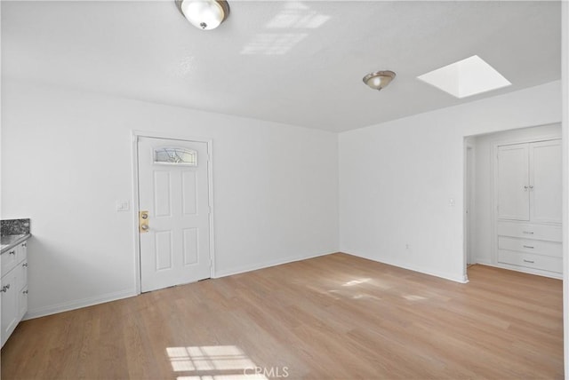 interior space with a skylight and light wood-type flooring