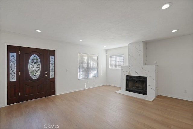 foyer featuring a high end fireplace and light hardwood / wood-style flooring