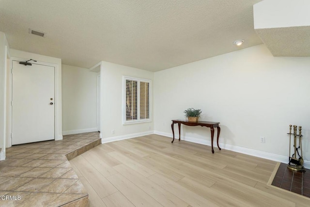 interior space with light hardwood / wood-style flooring and a textured ceiling