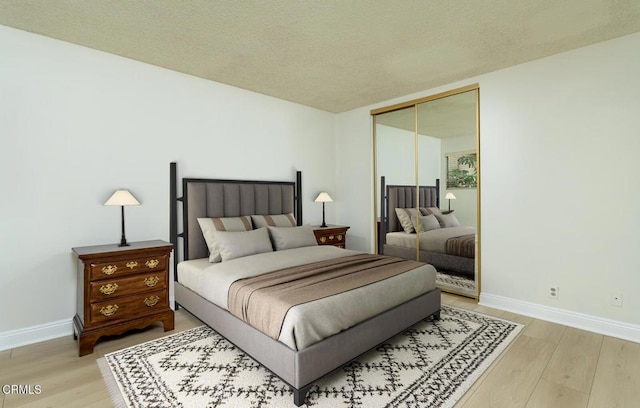 bedroom featuring hardwood / wood-style floors, a closet, and a textured ceiling