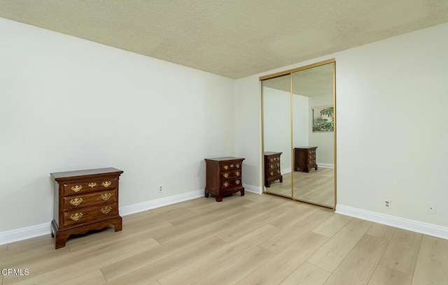 empty room featuring light hardwood / wood-style flooring and a textured ceiling