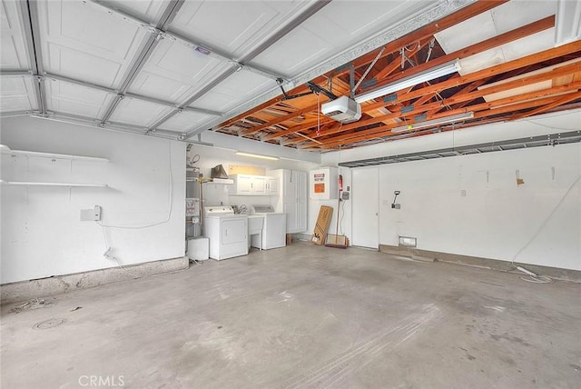 garage featuring strapped water heater, washing machine and dryer, and a garage door opener